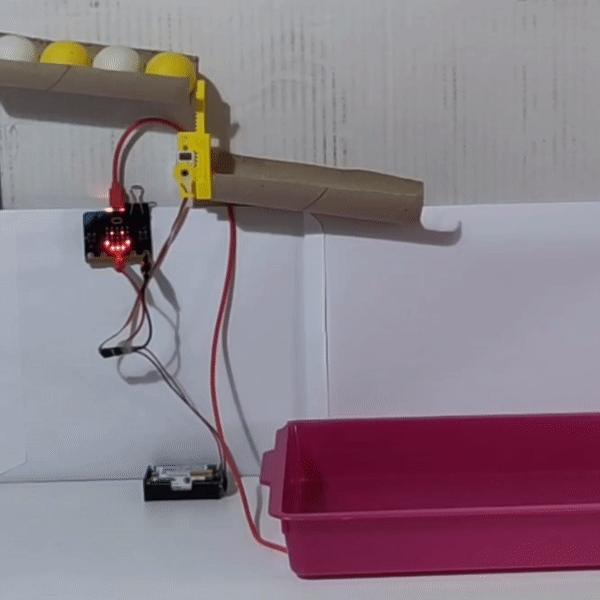 animated image showing a linear servo blocking ping pong balls in a tube. When the servo moves down, a ping pong ball drops out.